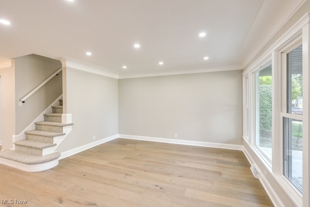 empty room featuring ornamental molding and light wood-type flooring