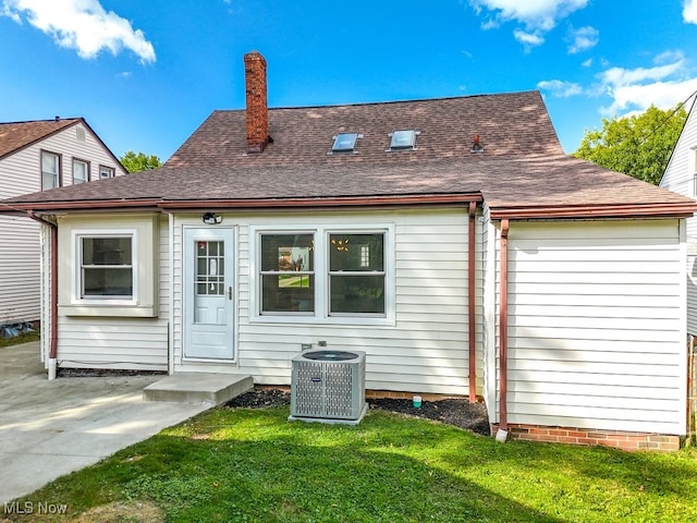 rear view of house featuring a yard and central air condition unit