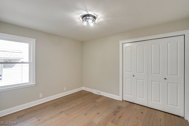 unfurnished bedroom featuring a closet and light hardwood / wood-style flooring