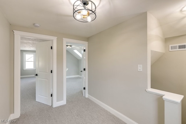 hallway featuring light colored carpet