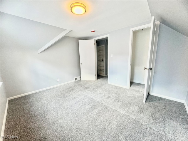 unfurnished bedroom with light colored carpet and vaulted ceiling