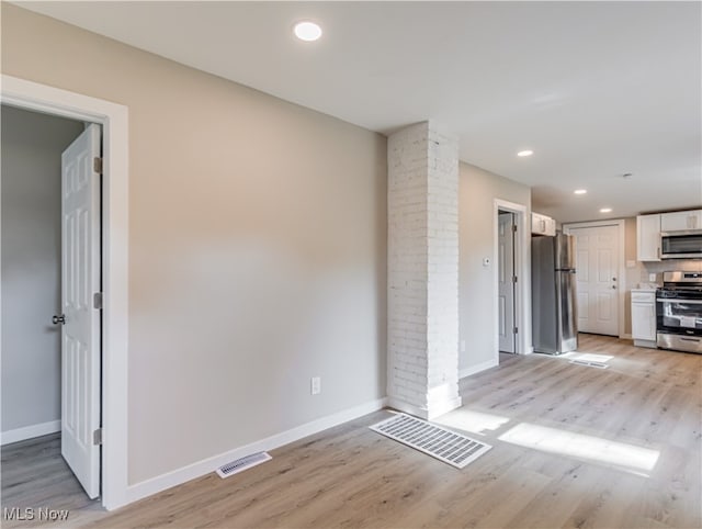 interior space with decorative columns and light hardwood / wood-style flooring