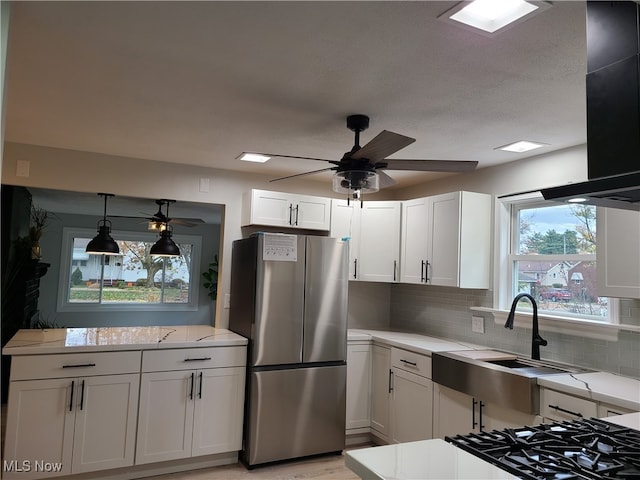 kitchen with stainless steel fridge, decorative light fixtures, white cabinets, decorative backsplash, and ventilation hood