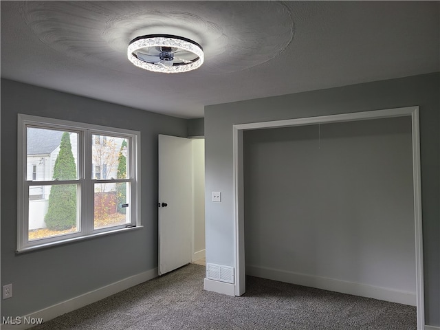 unfurnished bedroom featuring carpet and a textured ceiling