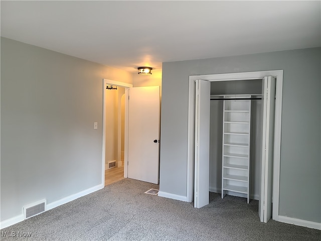 unfurnished bedroom featuring carpet floors and a closet