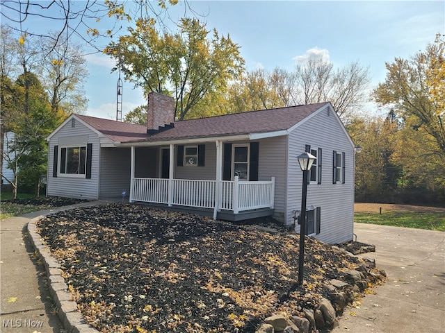 single story home featuring central air condition unit and a porch