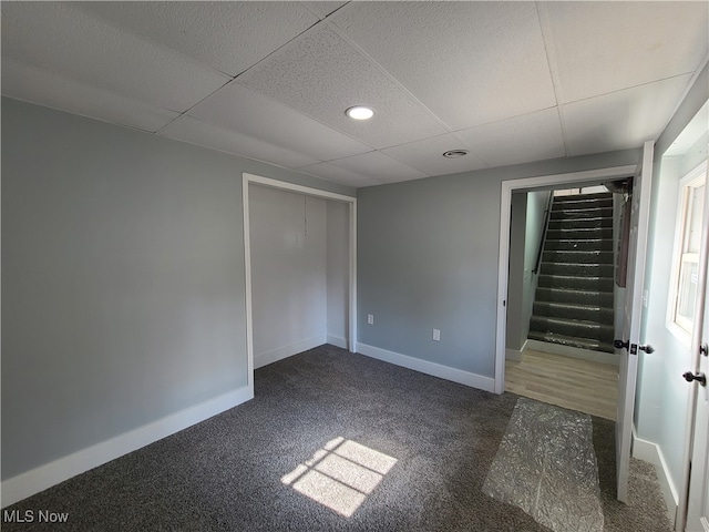 carpeted spare room featuring a paneled ceiling