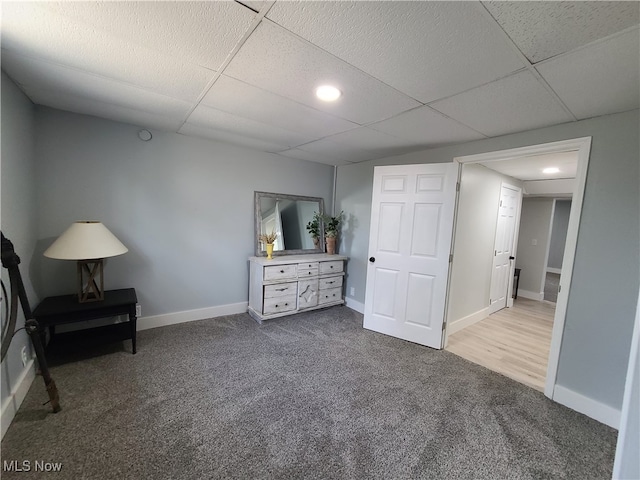 unfurnished bedroom with a paneled ceiling and carpet flooring