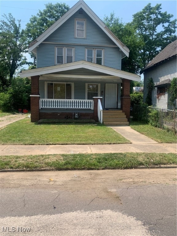 view of front of home with a front yard and covered porch