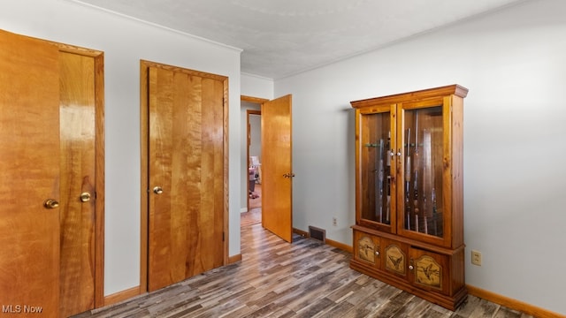 hall with hardwood / wood-style floors and crown molding