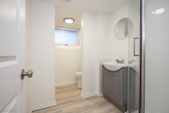 bathroom featuring vanity, an enclosed shower, hardwood / wood-style flooring, and toilet