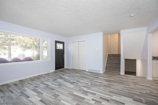 foyer featuring light hardwood / wood-style floors and a textured ceiling