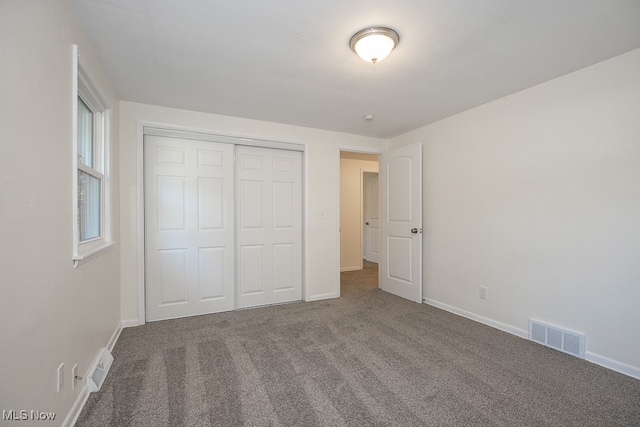 unfurnished bedroom with a closet and carpet flooring