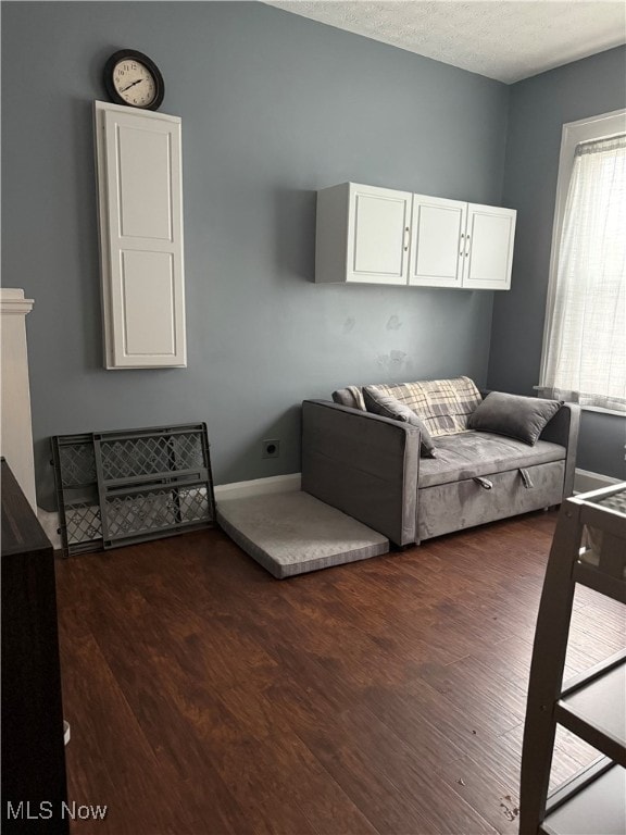 living room featuring a textured ceiling and dark hardwood / wood-style floors