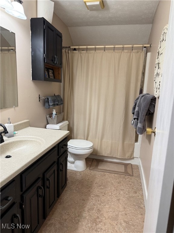 bathroom with vanity, a textured ceiling, toilet, and vaulted ceiling