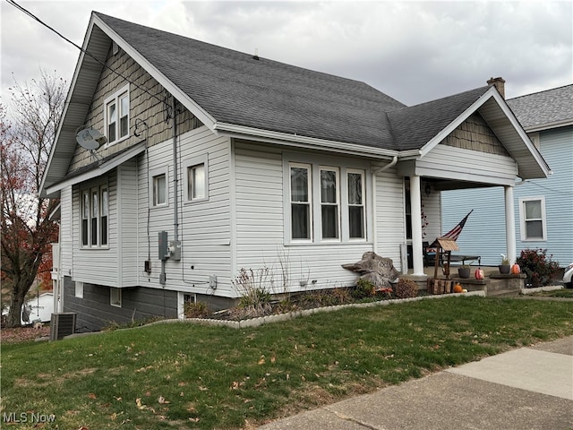 view of front of property with central air condition unit and a front yard