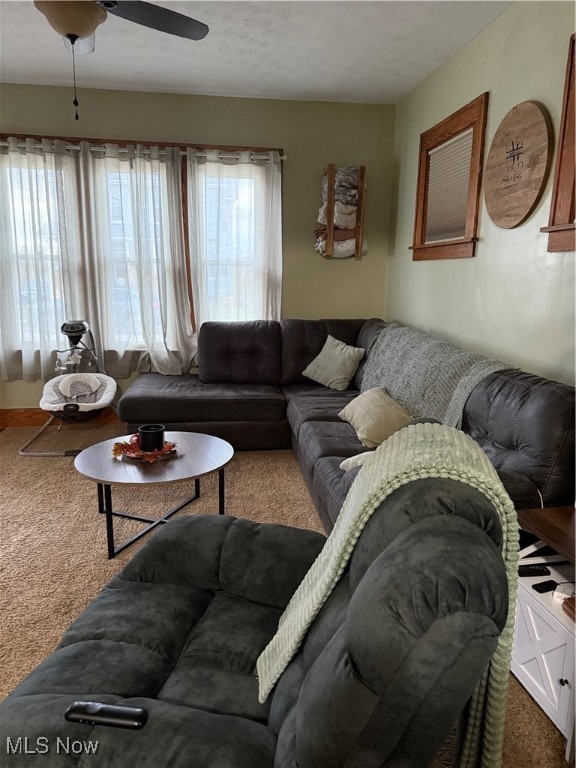 carpeted living room with a textured ceiling and ceiling fan