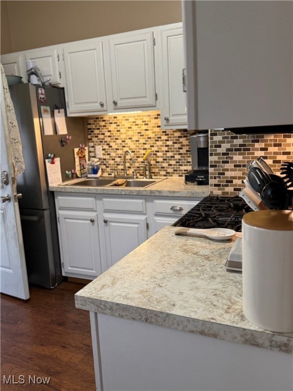 kitchen featuring sink, white cabinets, decorative backsplash, and dark hardwood / wood-style floors