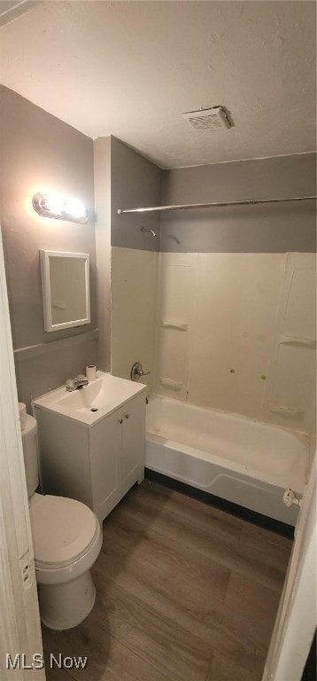 full bathroom featuring vanity, toilet,  shower combination, and wood-type flooring