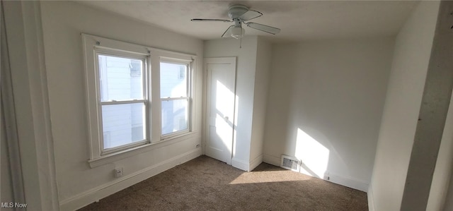 carpeted spare room with ceiling fan