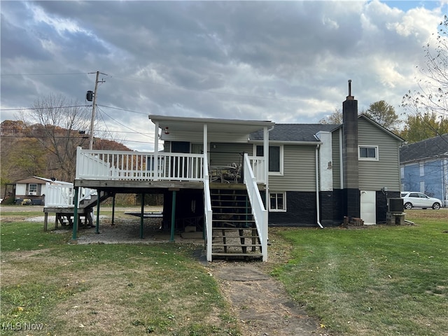 rear view of property featuring a yard and a deck