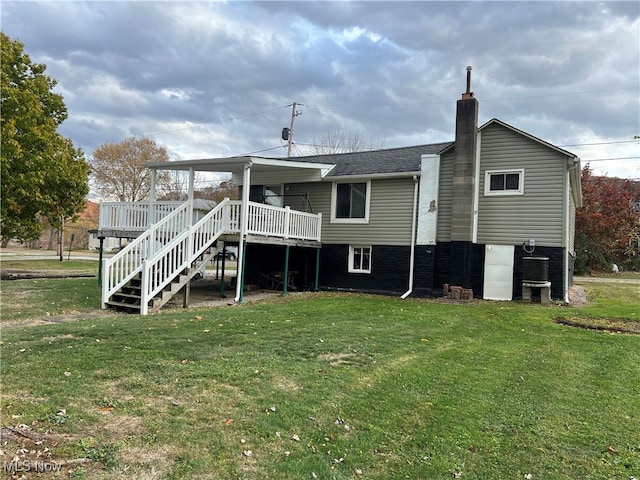 rear view of property with a wooden deck and a lawn