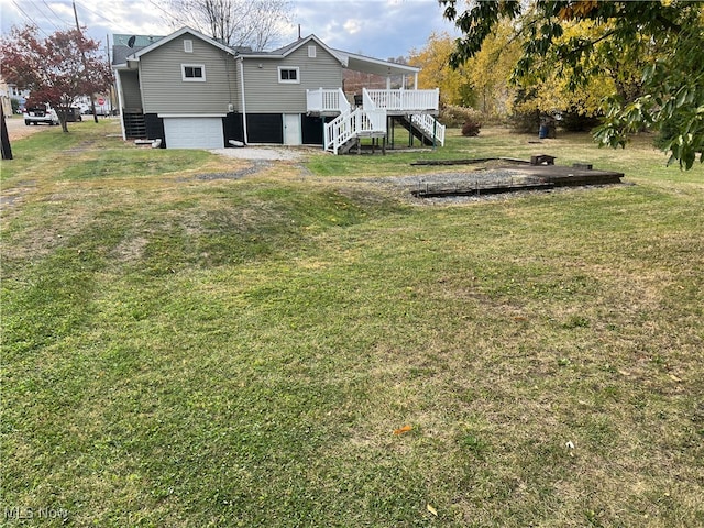 view of yard with a wooden deck and a garage