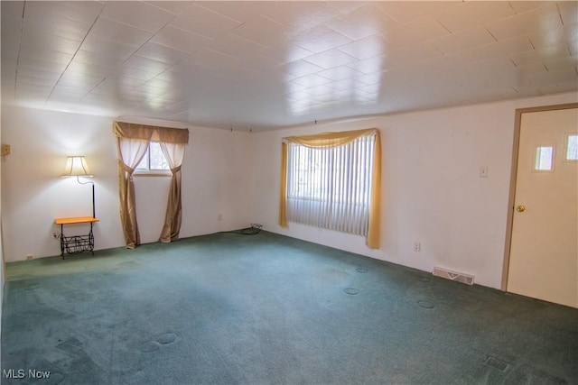 carpeted empty room featuring visible vents