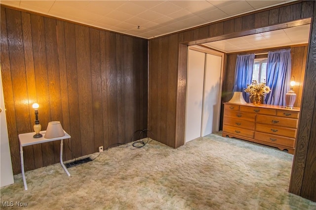 bedroom with visible vents, light carpet, and wooden walls