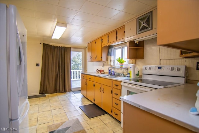 kitchen with open shelves, light countertops, light tile patterned flooring, a sink, and white appliances