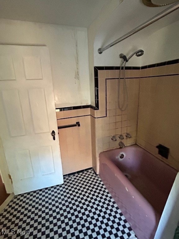 bathroom featuring tile walls and tiled shower / bath combo