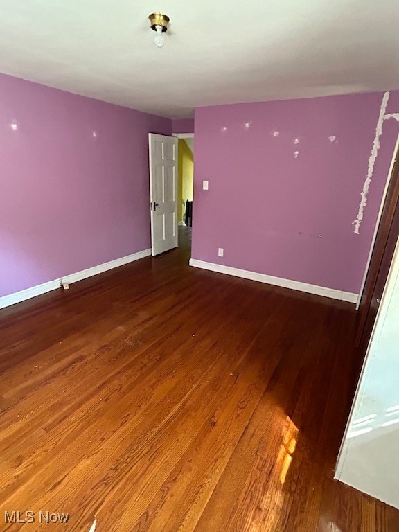 unfurnished room with hardwood / wood-style flooring