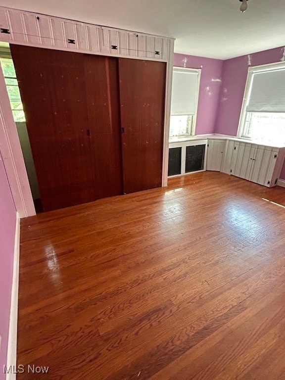 unfurnished bedroom with a closet and wood-type flooring