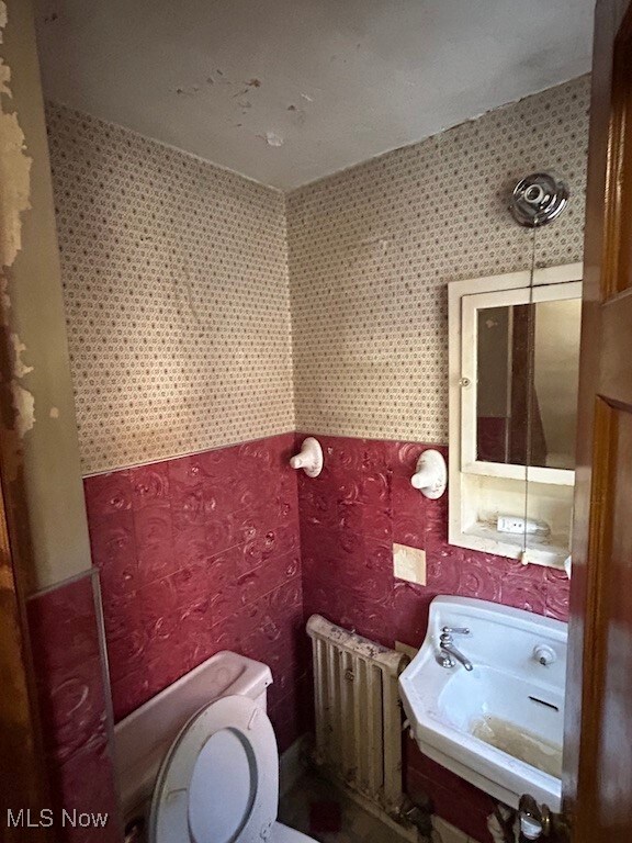 bathroom with radiator heating unit and toilet