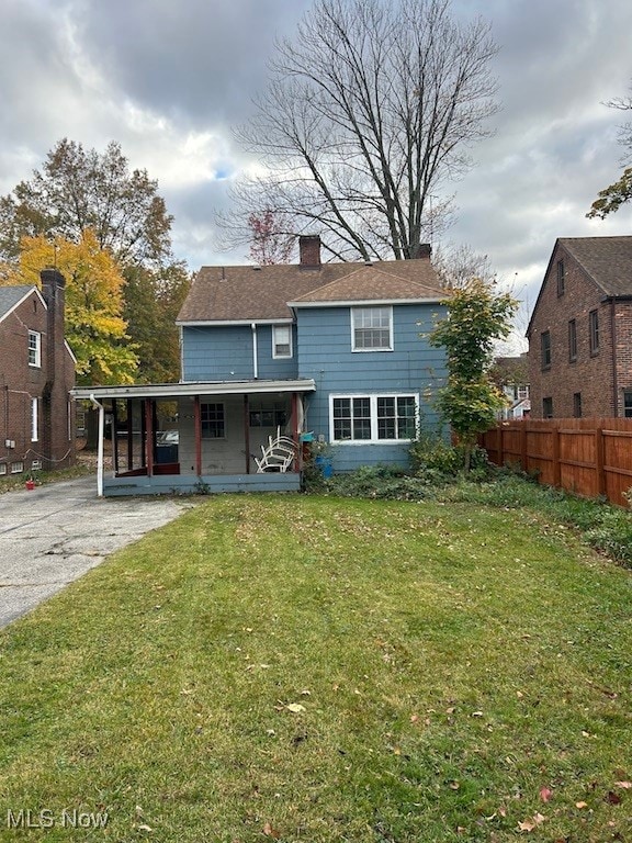 back of property with a porch and a yard