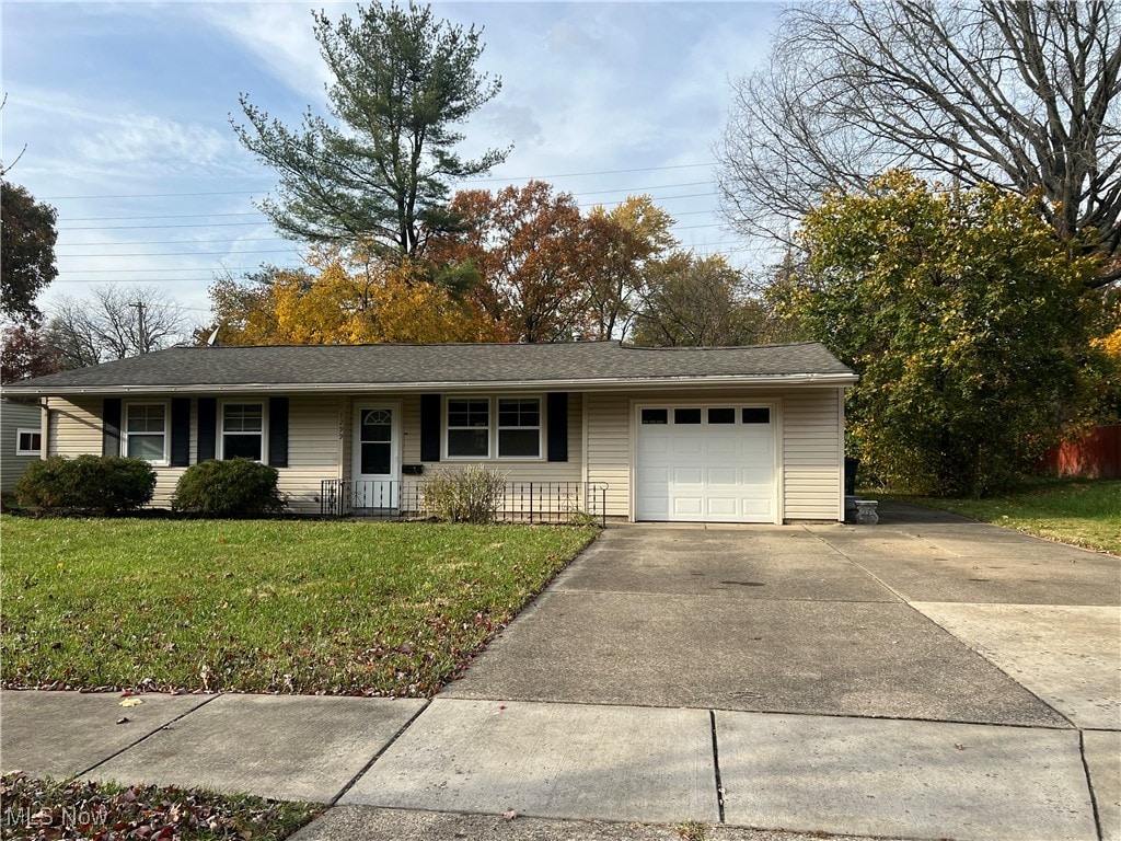 single story home with a front yard and a garage