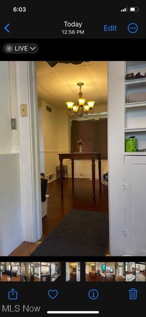 hallway with a chandelier and wood-type flooring