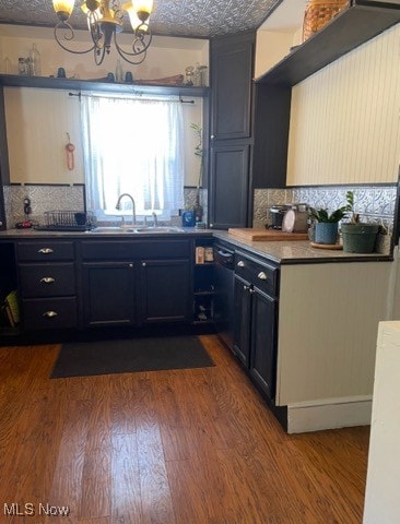 kitchen with dark hardwood / wood-style flooring, decorative backsplash, sink, and a textured ceiling