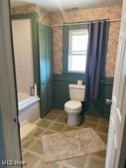 bathroom featuring toilet and a shower with shower curtain