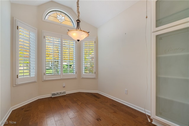 spare room with dark wood-type flooring, lofted ceiling, and plenty of natural light