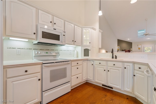 kitchen with sink, white cabinetry, wood-type flooring, and white appliances