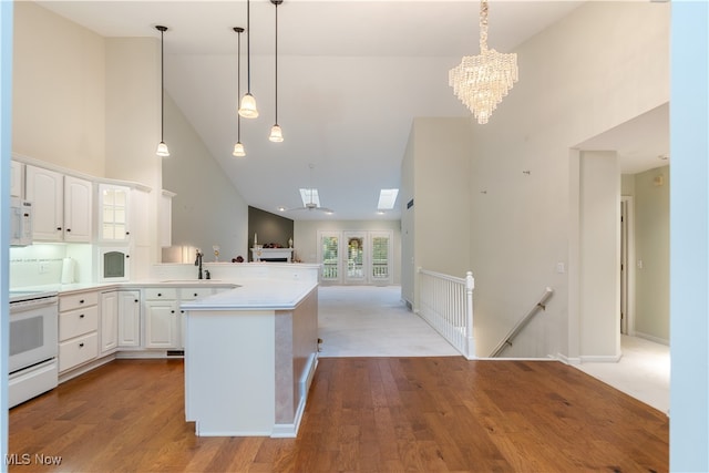 kitchen featuring white appliances, high vaulted ceiling, white cabinetry, and light hardwood / wood-style flooring