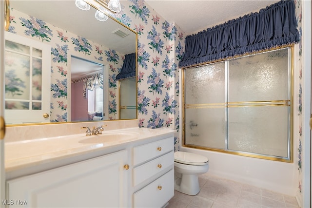 full bathroom with a textured ceiling, toilet, bath / shower combo with glass door, vanity, and tile patterned flooring