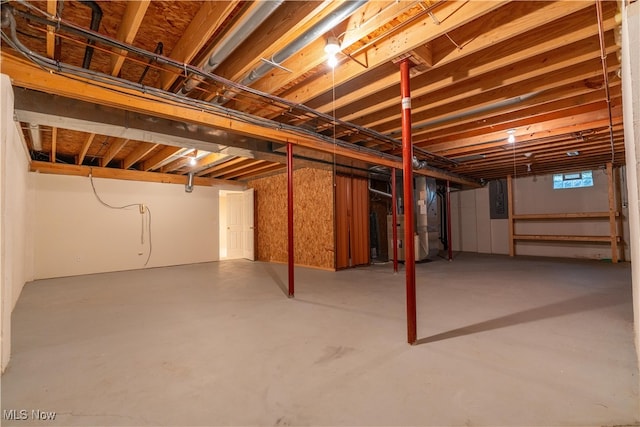 basement featuring electric panel and heating unit