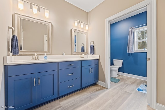 bathroom with hardwood / wood-style floors, vanity, and toilet