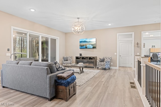 living room featuring a chandelier and light wood-type flooring