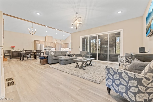 living room with vaulted ceiling, light wood-type flooring, a textured ceiling, and a chandelier