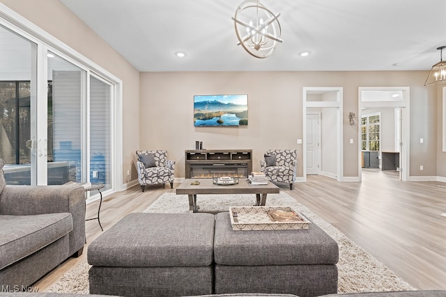 living room with an inviting chandelier and light wood-type flooring