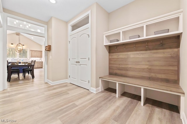 mudroom with light hardwood / wood-style floors and vaulted ceiling