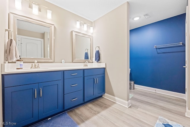 bathroom with hardwood / wood-style floors, vanity, and a textured ceiling